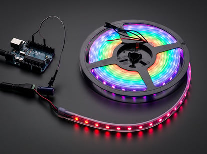 Adafruit NeoPixel Digital RGB LED Strip - White 60 LED - WHITE - 4m - Adafruit NeoPixel Digital RGB LED Strip reel wired to a microcontroller, with all the LEDs in a rainbow