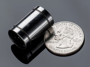 Long Linear Ball Bearing next to quarter