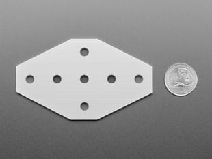 aluminum, 7-holed, cross-plate with U.S. quarter for scale.