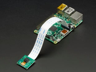 Angled shot of Raspberry Pi Camera Board connected to a flex cable and a Raspberry Pi.