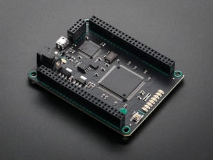 Angled shot of black microcontroller with socket riser headers.