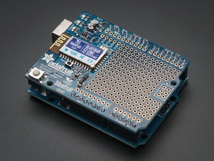 Angled shot of blue, credit-card-sized Bluetooth add-on board assembled on top of similarly sized microcontroller.