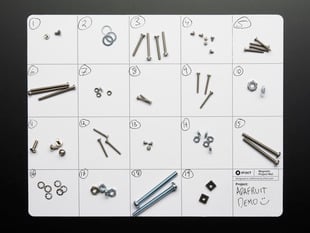 gridded mat with disassembed screws and nuts on it