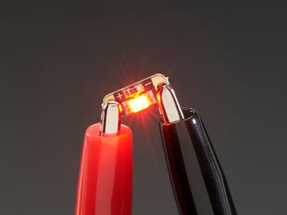 Adafruit LED Sequins - Ruby Red - Pack of 5 - Single LED sequin PCB attached to two alligator clips, glowing red