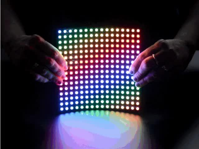 Flexible 16x16 NeoPixel RGB LED Matrix - Video of two white hands holding a rainbow pulsing Flexible 16x16 NeoPixel RGB LED Matrix.
