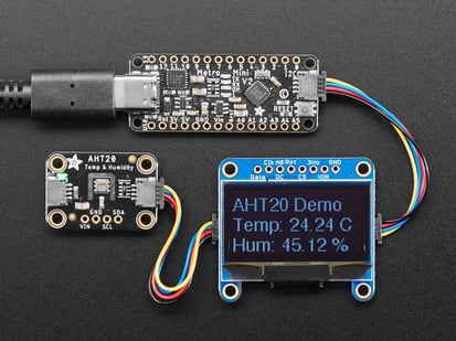 Adafruit Metro Mini 328 V2 - Arduino-Compatible - 5V 16MHz - STEMMA QT / Qwiic - Overhead shot of long skinny black microcontroller connected to an OLED screen and a temperature-and-humidity sensor. The sensor data displays on the OLED.