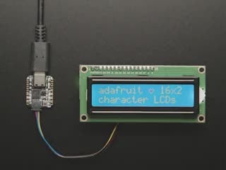Overhead video demo of an LCD backpack wired to a small square microcontroller. Display on LCD reads: "adafruit (heart symbol) 16x2 character LCDs"