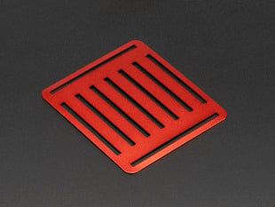 Angled shot of slotted red aluminum sheet.