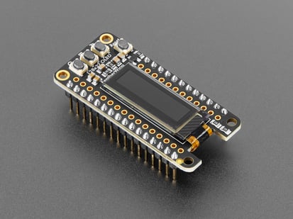 Assembled Adafruit FeatherWing OLED - 128x32 OLED Add-on For Feather - Angled shot of black, rectangular, OLED display breakout with headers.