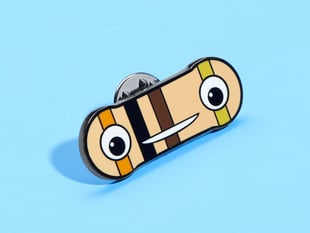 Angled shot of enamel pin resembling a smiley face resister.