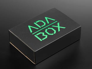 Angled shot of a black box with Green "ADABOX" texted logo.
