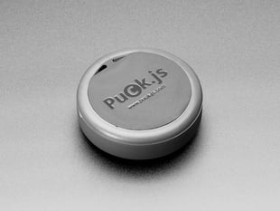 Angled shot of black, round, smart button with rubber ring.