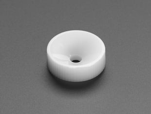 Angled shot of small, white, circular camera lens adjustment knob.