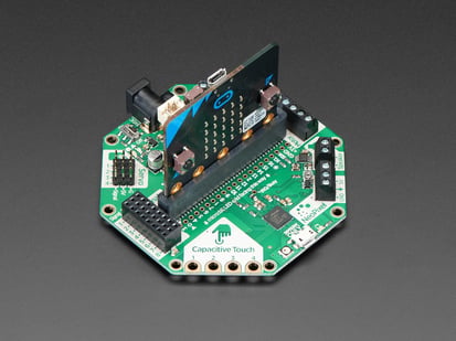 Adafruit CRICKIT for micro:bit - Angled shot of a Adafruit CRICKIT for micro:bit connected to a black squared board.