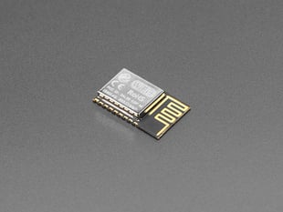 Angled shot of small, rectangular, Wi-Fi module with castellated pads.