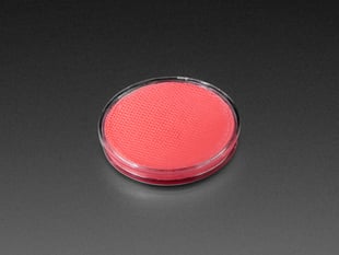 Angled shot of round pink disc of fluorescent paint.