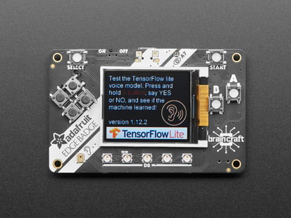 Adafruit EdgeBadge - TensorFlow Lite for Microcontrollers - Top view of Adafruit EdgeBadge - Display reads "Test the TensorFlow lite voice model. Press and hold A button, say YES or NO, and see if the machine learned!".