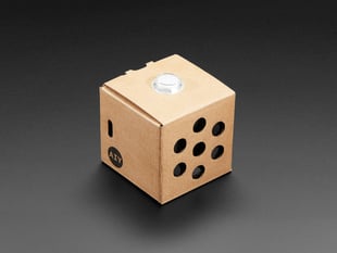 Angled shot of assembled cardboard cube with white button.