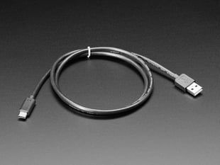 Angled shot of a coiled black, USB-C to USB-A cable.