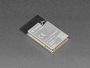 Angled shot of small, black, Wi-Fi module with castellated pads.