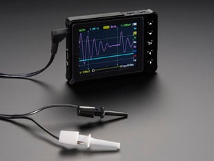 Angled shot of a DSO Nano v3 - Pocket-size color digital oscilloscope with hook probes. 