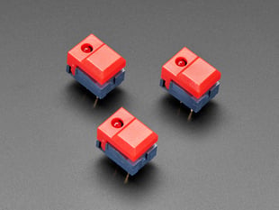 Angled shot of three red plastic step-switches with red LEDs.