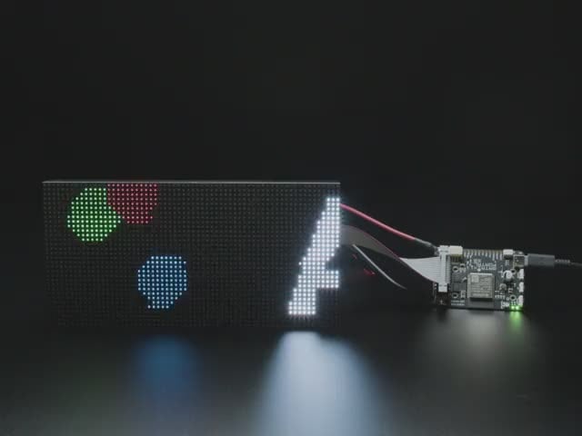 Adafruit Matrix Portal S3 CircuitPython Powered Internet Display - Video of Adafruit Matrix Portal S3 linked up to a matrix displaying the "Adafruit Matrix Portal" in white letters and red, green and blue circles jumping around. 