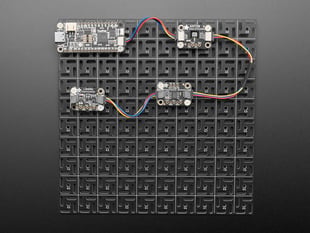 Overhead shot of 10x10 aluminum prototyping grid with a microcontroller and three breakout boards.