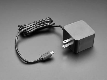 Official Raspberry Pi 27W PD Power Supply 5.1V 5A with USB C - Angled shot of black, square-shaped power supply block with a coiled black cable.