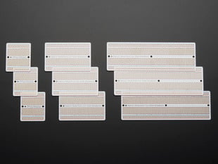 Top view of three packs of three different sized Adafruit Perma Proto-Board PCBs.