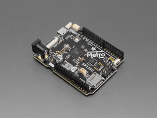 Angled shot of black, credit card-sized microcontroller with stacking headers.