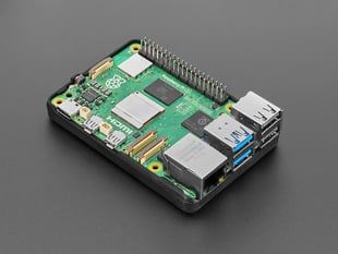 Angled shot of green, credit-card-sized microcontroller in black rubber bumper case.