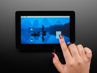 Overhead shot of a Black hand with red manicure drawing a rectangle on a touchscreen landscape-style.