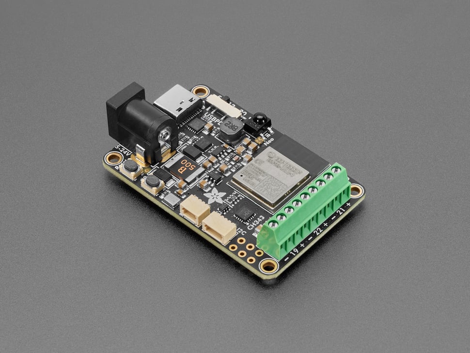 Angled shot of rectangular LED driver PCB with green terminal blocks.