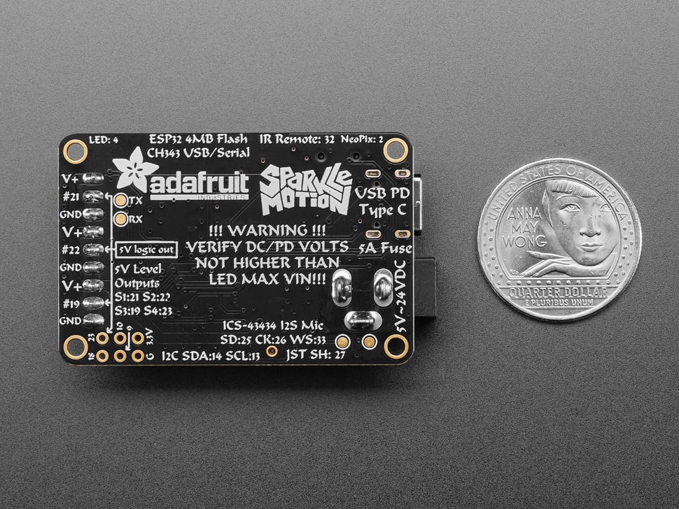 Back of rectangular PCB next to US quarter for scale.