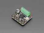 Angled shot of square-shaped motor driver breakout with green terminal blocks.