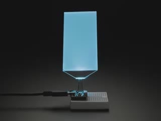 Video of large, rectangular backlight display plugged into a small breadboard with microcontroller. Backlight display cycles through colors.