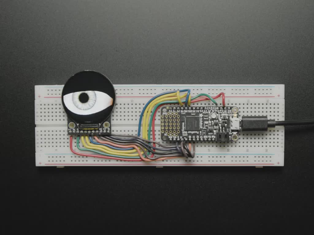 Video of a round TFT display assembled onto a breadboard with a microcontroller. The TFT shows a blinking eyeball animation.
