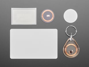 Assortment of five RFID tags: card, sticker, keychain fob, clear circle tag, and white circle tag.