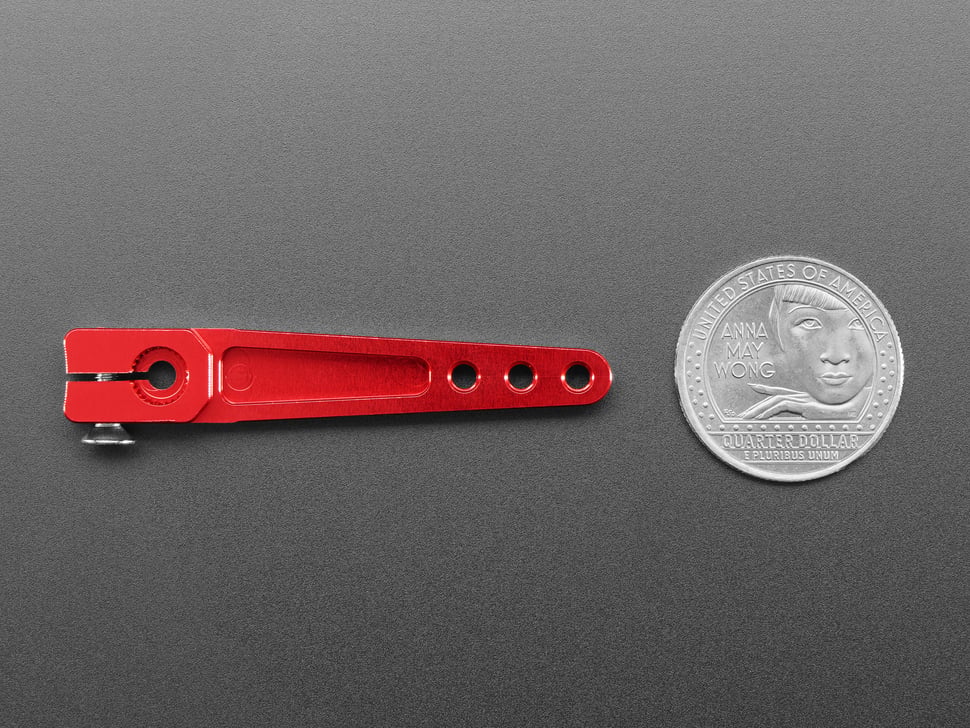 Red servo arm with U.S. quarter for scale.