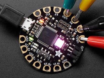 FLORA - Wearable electronic platform: Arduino-compatible - v3 - Top down view of a FLORA - Wearable electronic platform: Arduino-compatible connected to 4 alligator clips and a USB powerin the FLORA. 