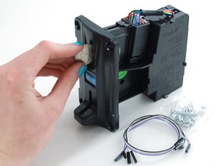 Hand inserting quarter into coin mechanism slot