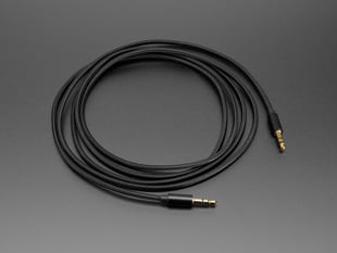 Long, black fabric woven stereo plug cable coiled in a circle.